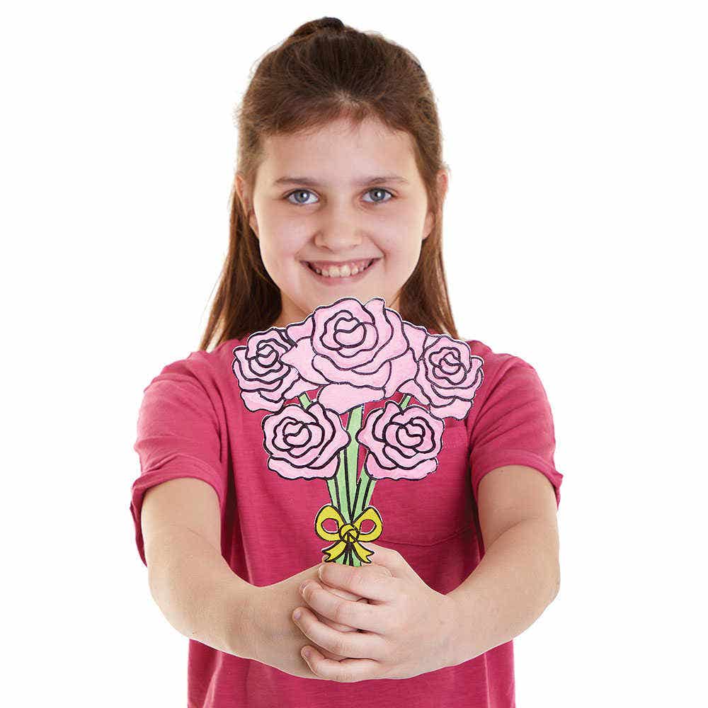 Bloemen Boeketten Van Hout: lachend meisje houdt een houten bos roze bloemen met groene stelen en gele strik tegen witte achtergrond